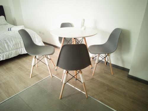 three chairs and a table in a room with a bed at Edificio Urban in Cajicá