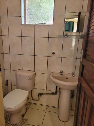 a bathroom with a toilet and a sink at Guestmate Inn in Livingstone