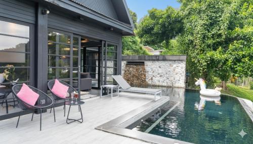 カマラビーチにあるJaokhun Hilltop Kamala, Phuketの椅子と白鳥が置かれたプールのある家