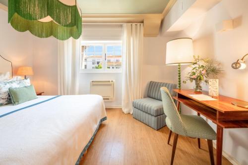 a hotel room with a bed and a desk and a chair at Pergola Boutique Hotel in Cascais