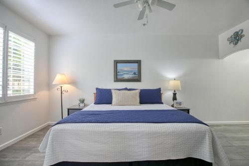 a white bedroom with a large bed with blue pillows at Pacific Plaza #304 - Condo on the Coastline - 1BdrmD-K-QSofa in Oceano