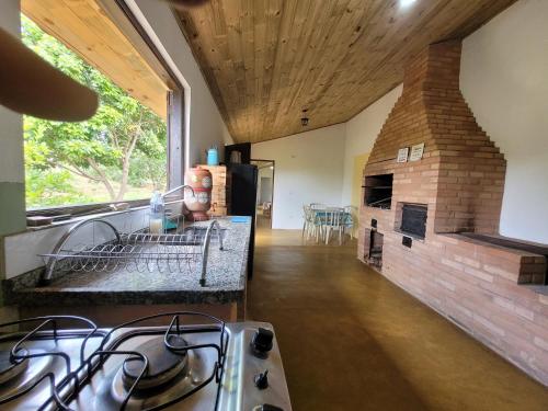 a kitchen with a stove and a brick fireplace at EcoviLab in Guaratinguetá