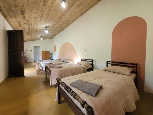 a room with three beds and a wooden ceiling at EcoviLab in Guaratinguetá