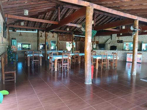 a dining room with tables and chairs in a building at Pousada Tropical Vereda in Olímpia