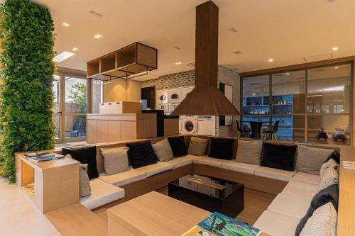 a living room with a large couch and a kitchen at Colibri -ZCotovia Luxo e Aconchego in Sao Paulo