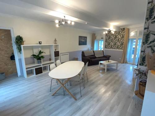 a living room with a table and a couch at Appartement chaleureux aux portes de Navarrenx - Fibre in Susmiou
