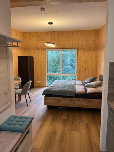 a bedroom with a bed and a desk and a window at Hofquartier Retzmoar - Familie Hörmann in Bruck an der Mur