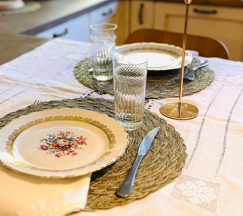 a table with plates and glasses on a table at La casa di Eleonora in Roccabruna