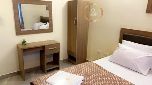 a hotel room with a bed and a mirror at Iconic Hotel and Lounge in Alagbado