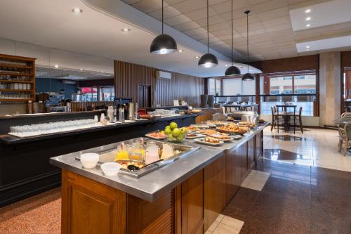 a buffet line with food on it in a restaurant at Golden Beach Resort & Spa in Punta del Este