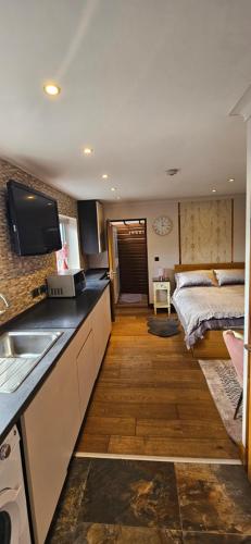 a kitchen with a sink and a bed in a room at Cosy Studio Quest House in Romford