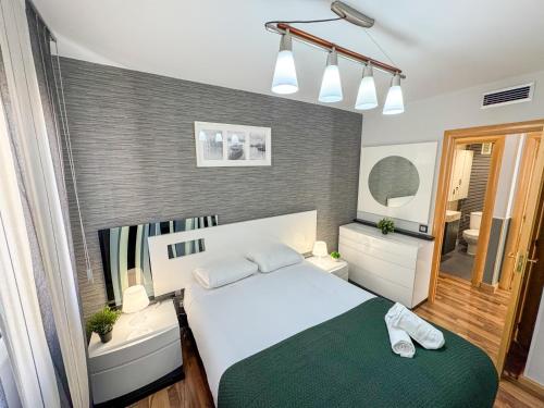 een slaapkamer met een groot wit bed en een badkamer bij Cineasta del Pilar - Turistea in Zaragoza