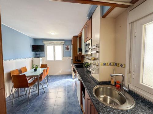 een keuken met een spoelbak en een tafel met stoelen bij Cineasta del Pilar - Turistea in Zaragoza