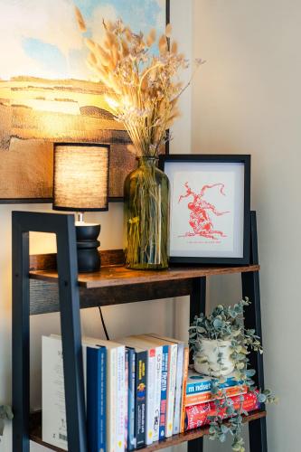 a book shelf with a vase of flowers and books at Ashdown Forest Retreat in Nutley
