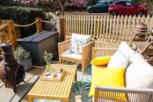 a patio with a couch and a table and a fence at Ashdown Forest Retreat in Nutley