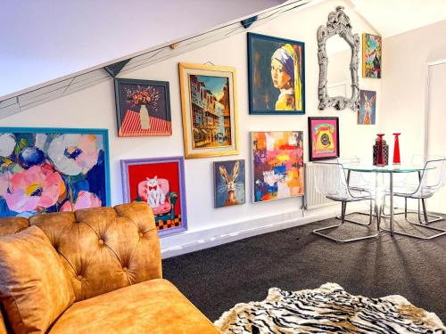 a living room with a couch and a wall of paintings at Designer 2-Bed Flat by Tower Bridge in London