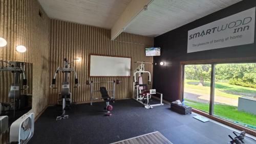 a gym with treadmills and machines in a room at Smartwood Inn in Osseo