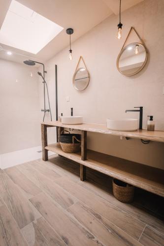 a bathroom with a large sink and two mirrors at La maison de July in La Roë