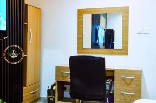 a black chair sitting in front of a desk with a mirror at Iconic Hotel and Lounge in Alagbado