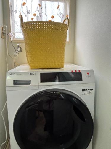 a washing machine with a basket on top of it at Stay Chacha 城下町茶茶2F in Marugame