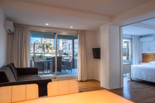 a living room with a couch and a bed and a table at Golden Beach Resort & Spa in Punta del Este