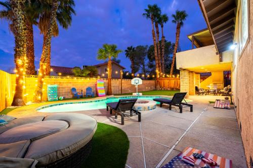 a backyard with a swimming pool and palm trees at Strip-side Villa Pool, Mini Golf, Casino games in Las Vegas