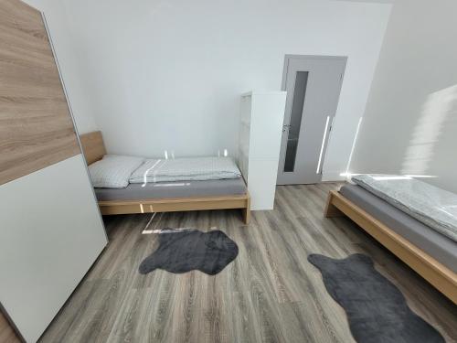 a room with two beds and a wooden floor at Apartmán Neva Galanta 2 in Galanta