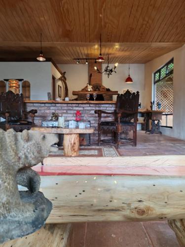 a dining room with a bear sitting on a bench at Finca Chuchiyá cabañas Tecpan in Tecpán Guatemala