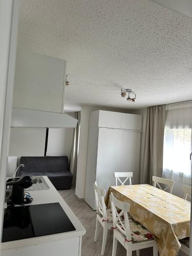 a kitchen and living room with a table and chairs at Snow Sky in Passo del Tonale