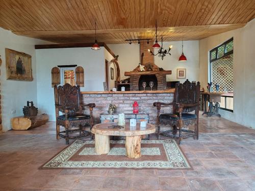 a living room with a table and chairs and a fireplace at Finca Chuchiyá cabañas Tecpan in Tecpán Guatemala