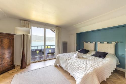 a bedroom with a large bed and a large window at Maison Ponton - Logement familial avec accès privatif au lac in Veyrier-du-Lac