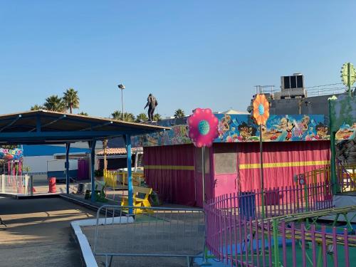 a playground at a park with a building with a mural at T2 Familial - 250 m front de mer, plage, seaquarium - parking privé - Bienvenue en occitanie in Le Grau-du-Roi