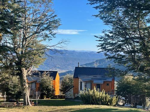 a house on a hill with mountains in the background at Bosque Nevado in San Martín de los Andes
