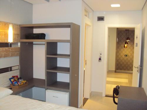 ein Schlafzimmer mit einem Bücherregal in einem Zimmer in der Unterkunft Hotel Imperatriz Premium in Telêmaco Borba