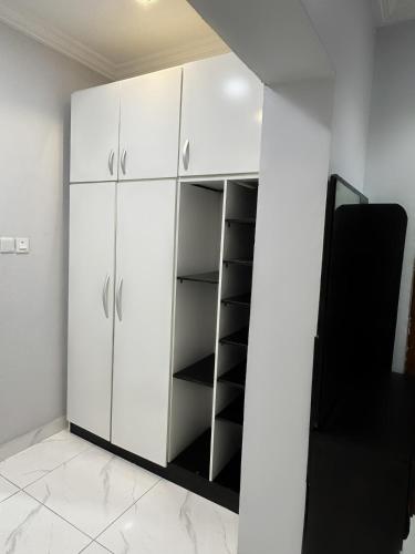 a white closet with black shelves in a room at Near Lakowe Golf and Lekki FTZ Minutes From Awoyaya with Constant Power, Wi-Fi, Gym by Crystal Stays in Eleputu
