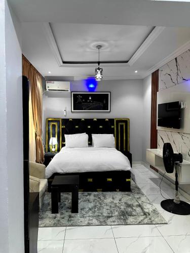 a bedroom with a large bed and a tv at Near Lakowe Golf and Lekki FTZ Minutes From Awoyaya with Constant Power, Wi-Fi, Gym by Crystal Stays in Eleputu