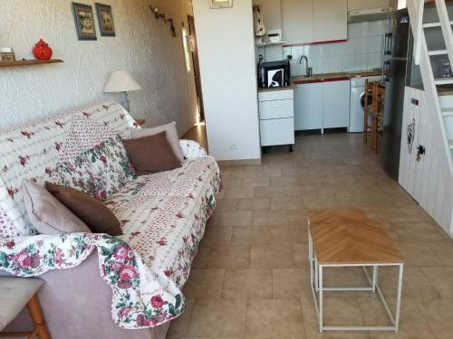 Sole & Mare Apartment في لوميو: غرفة معيشة مع أريكة ومطبخ
