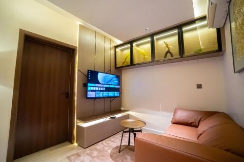 a living room with a couch and a tv at Greyfield Hotel in Benin City