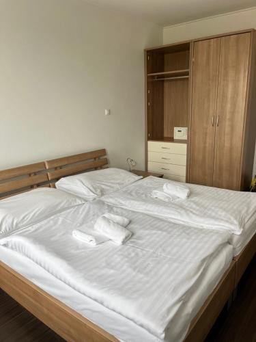a bed with two white towels on top of it at Fine Restaurant & Apartments in Malacky
