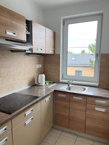a kitchen with a sink and a window at Fine Restaurant & Apartments in Malacky