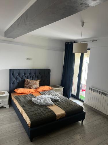 a bedroom with a large bed with orange pillows at Central Luxury Apartament in Tulcea