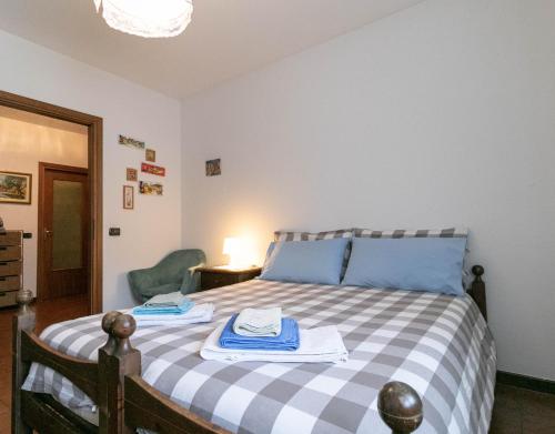 a bedroom with a bed with a blue and white checkered blanket at Welcomely - La Soliva Big House in Primaluna