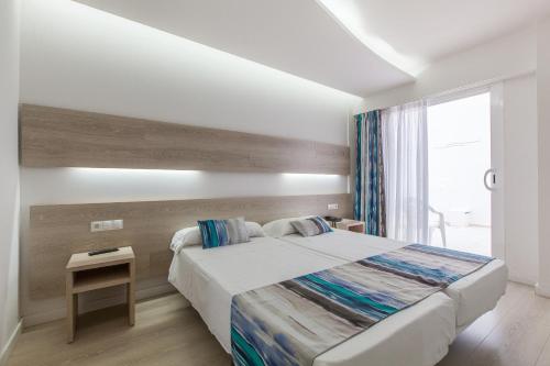 a bedroom with a large bed and a window at Hotel Gracia in El Arenal