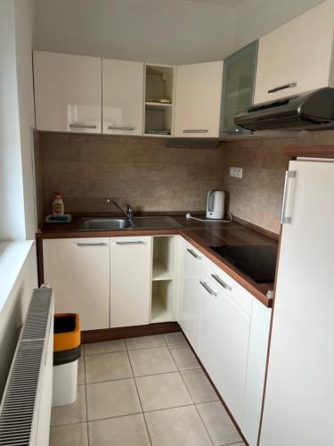a kitchen with white cabinets and a sink at Fine Restaurant & Apartments in Malacky
