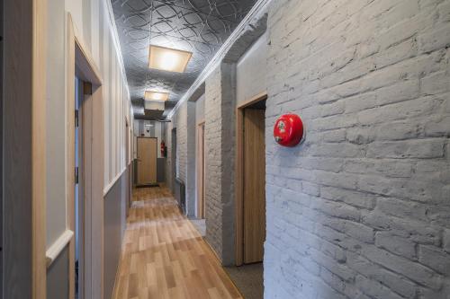 a hallway with a brick wall and a red fire alarm at Sodų 17 Self Check-in - Lollo Stay in Vilnius
