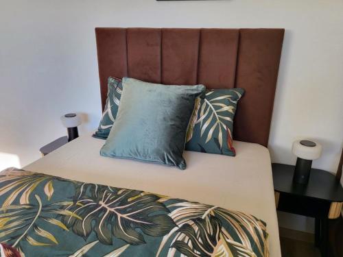 a bed with two blue pillows and a brown headboard at Ferienwohnung Irina Legoland ca 30 km in Gerstetten