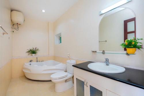 a bathroom with a toilet and a sink and a mirror at Biệt thự hồ bơi cho du khách bãi sau in Vung Tau