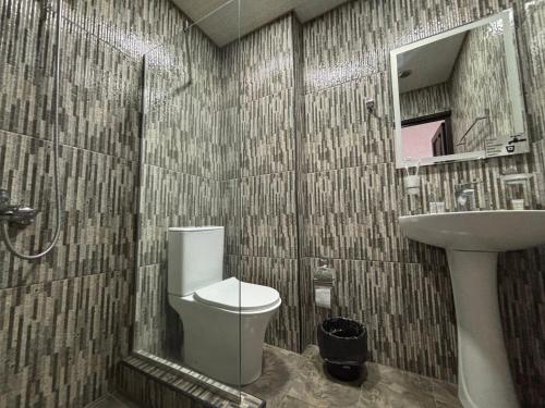 a bathroom with a toilet and a sink and a mirror at TIGRAN Hotel by Black & Gold in Goris
