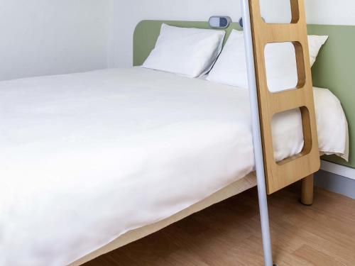 a bedroom with a bunk bed with a ladder at ibis budget Caen Hérouville in Hérouville-Saint-Clair