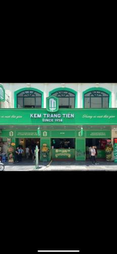 a building with a green and white sign on it at Rik Homestay in Hanoi